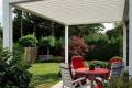 1500 Series Outdoor Shelter above a deck in a backyard garden