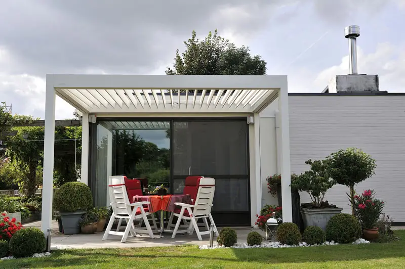 1500 Series Outdoor Shelter above a patio in a backyard garden