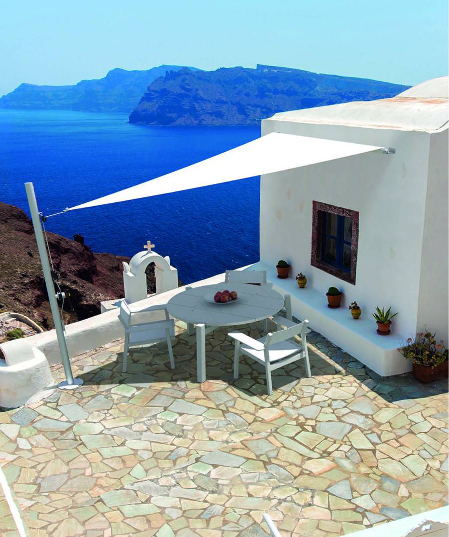 Velart Sail Shade providing shade next to a home beside the ocean