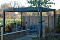 1500 Series Outdoor Shelter above a deck in a backyard garden