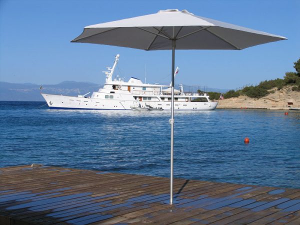 P50 Umbrella on a dock in Greece with a yacht on the water in the background