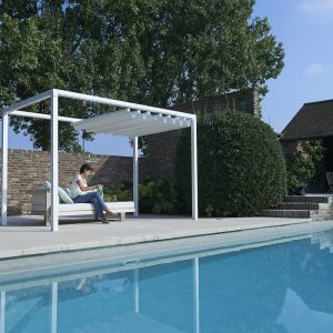 woman sitting under a Retractable Roof Poolside Cabana with a partially open roof