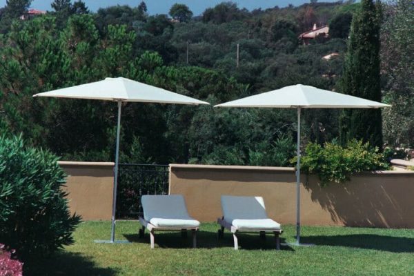 Two P50 Umbrellas shading reclined pool chairs on grass