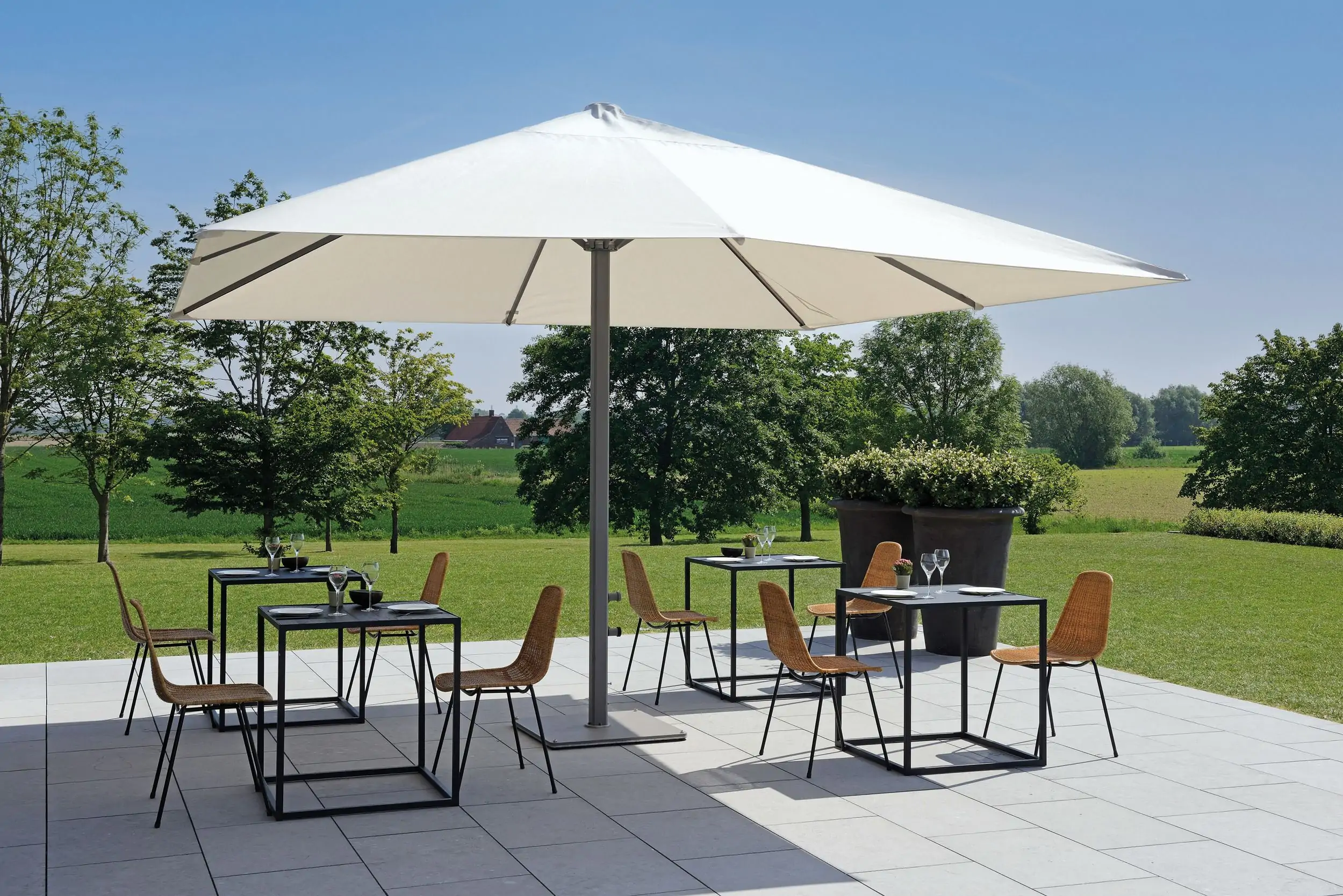 P8 umbrella on patio covering 4 small outdoor dining tables