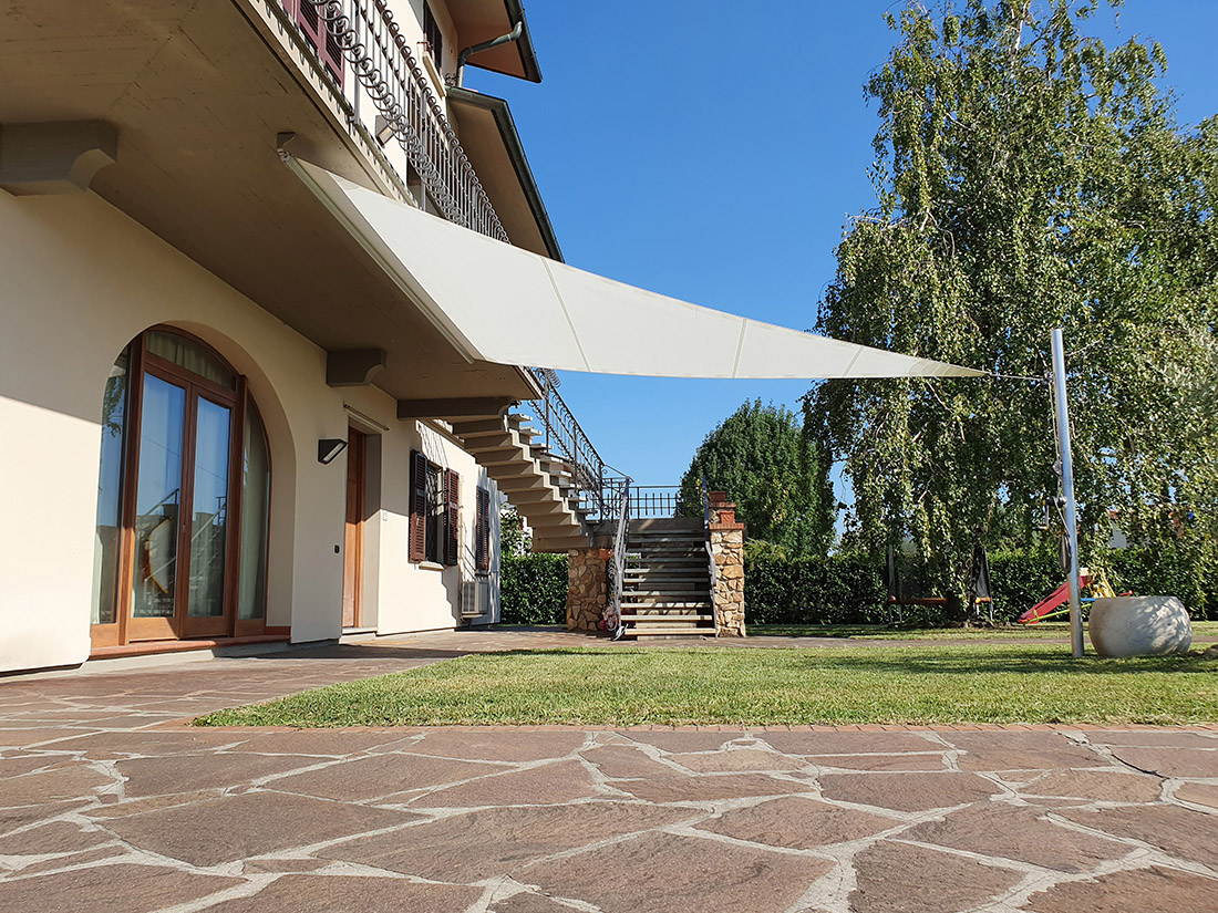 Velart Sail Shade under a deck covering a grassy area