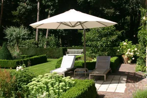 P7 umbrella with white canopy shading an outdoor seating area in a garden