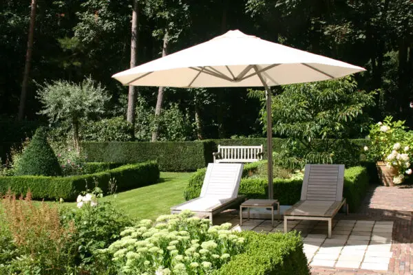 P7 umbrella with white canopy shading an outdoor seating area in a garden